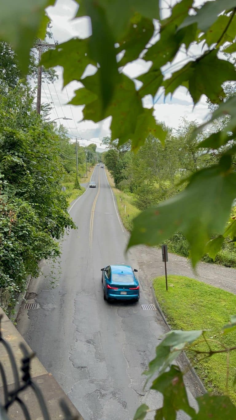 A car passes under a Norwottuck Rail Trail Bridge over South East Street in Amherst.